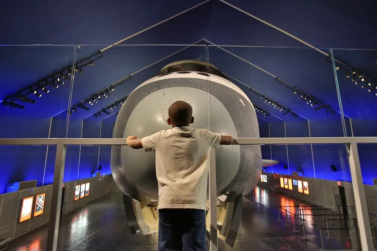 A young boy gazes out at the Entreprise in the Museum's Space Shuttle Pavillion.