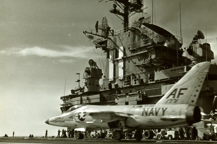 An archival photo of the Intrepid's flight deck with a navy plane on it, about to take off.