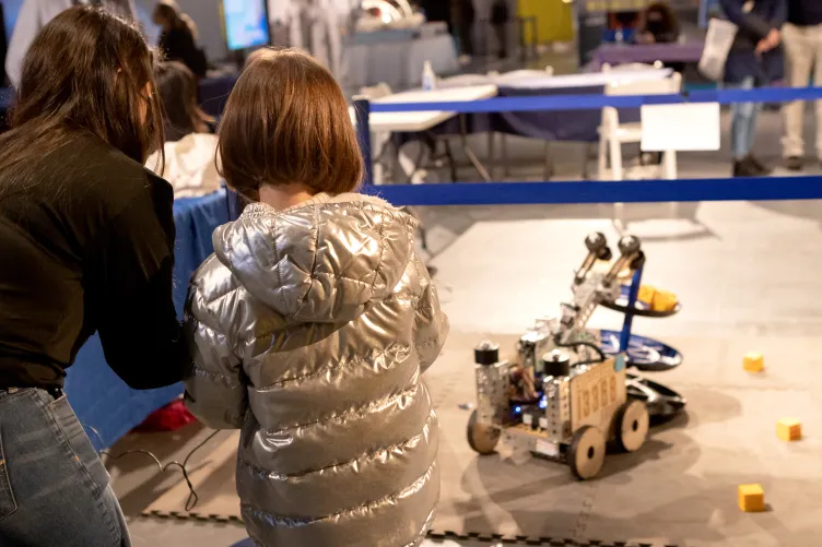 A young girl participating in robotics activities at a museum event