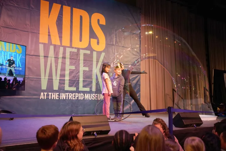 A Kids Week activity featuring a bubble balloon show on stage."