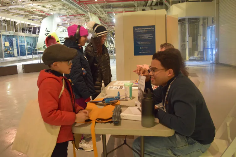 An educator engages with families during an activity at the Intrepid Museum.