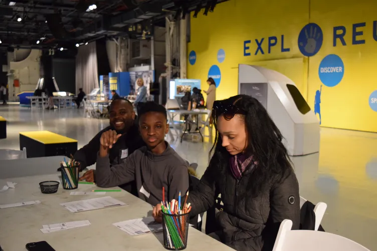 An educator engages with families during an activity at the Intrepid Museum.