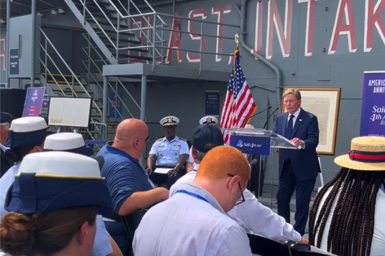 Ken Fisher speaking at a Sail4th 250 press conference on the Intrepid Museum’s flight deck.