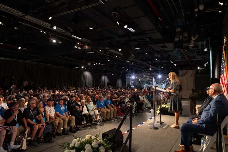 A woman giving a speech aboard the Intrepid
