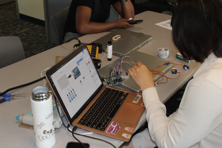 Young adults working with laptops and various electronics