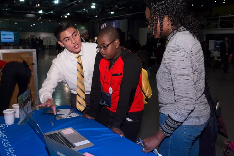 Family participating in a hands-on activity at an event table.