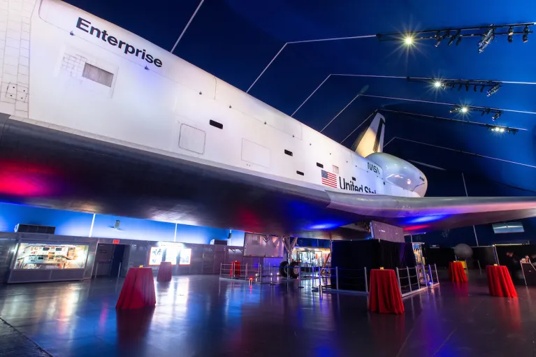 Space Shuttle Pavilion setup for a cocktail reception with red linen on high top tables