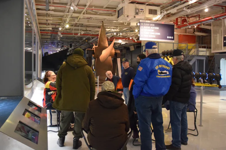 Museum educator guiding veterans on a tour after hours.