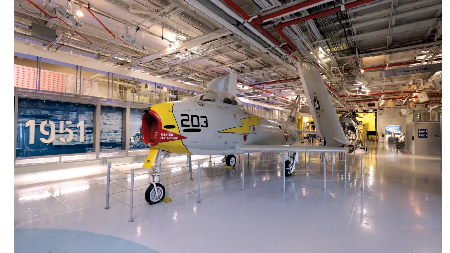 White, yellow and red FJ-3 FURY Aircraft displayed at the Hangar Deck.