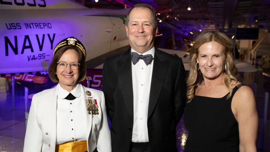 Intrepid executives and honorees posing in front of the Douglas A-4B Skyhawk.