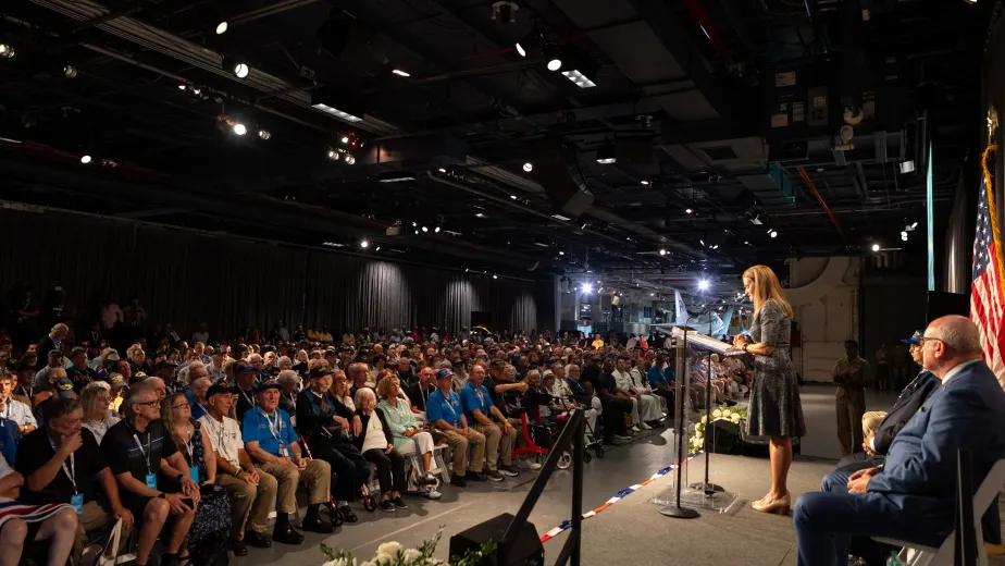 A woman giving a speech aboard the Intrepid