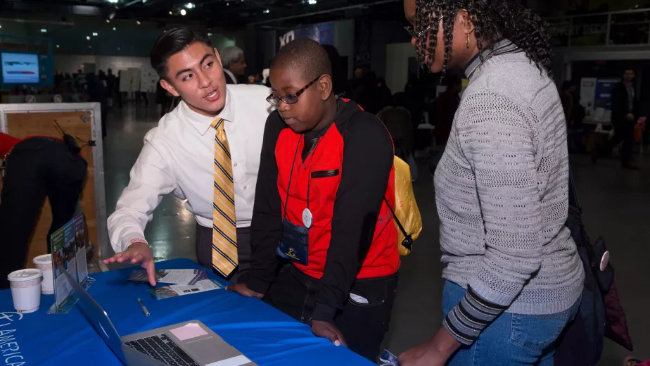 Family participating in a hands-on activity at an event table.